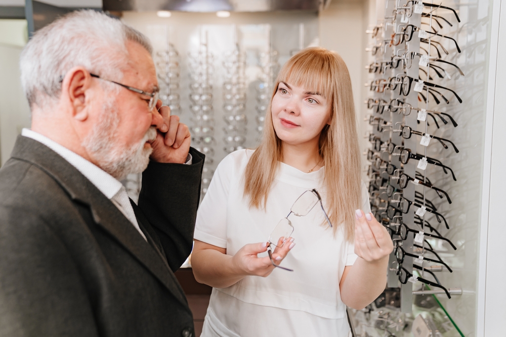 An optician helping a customer choose glasses